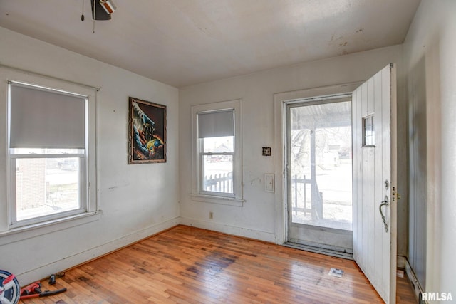 doorway with hardwood / wood-style flooring, ceiling fan, and plenty of natural light