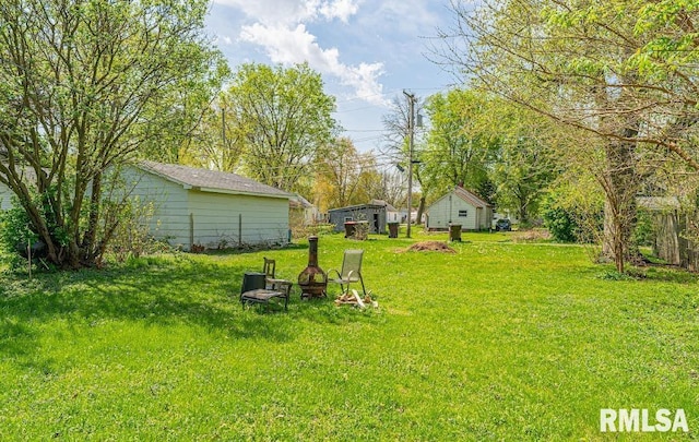 1405 Pekin St, Lincoln, IL 62656 - view of green lawn with an outdoor fire pit and an outdoor structure