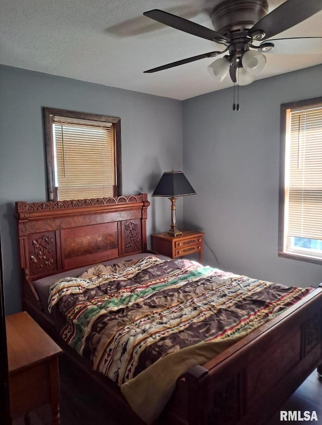 bedroom with ceiling fan and a textured ceiling