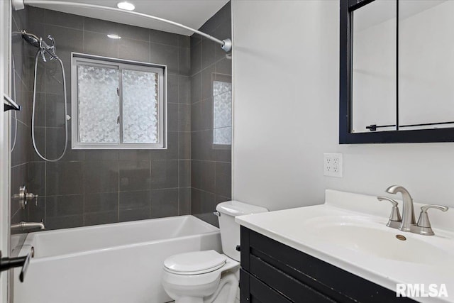 full bathroom featuring tiled shower / bath combo, vanity, and toilet