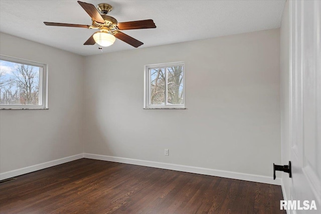 spare room with plenty of natural light, dark wood-type flooring, and ceiling fan