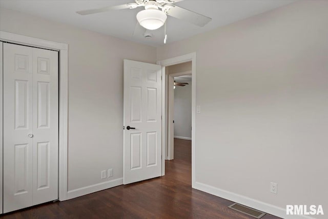 unfurnished bedroom featuring dark wood-type flooring, ceiling fan, and a closet