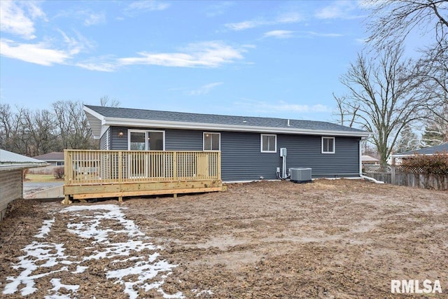 snow covered house featuring central AC and a deck