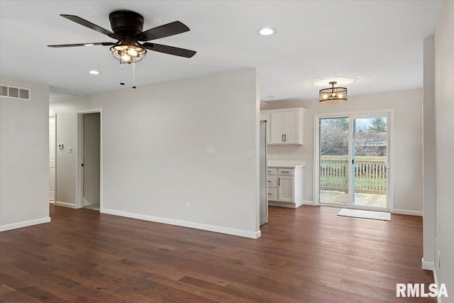 unfurnished living room featuring dark hardwood / wood-style floors and ceiling fan