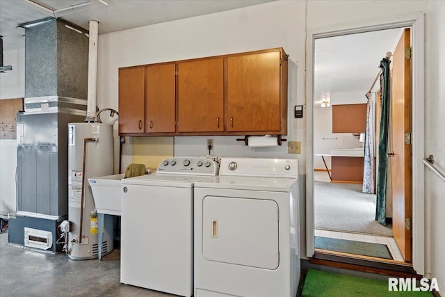 washroom with cabinets, washer and clothes dryer, and water heater