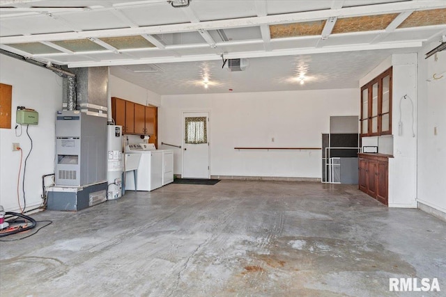 garage with a garage door opener, gas water heater, washer and clothes dryer, and heating unit