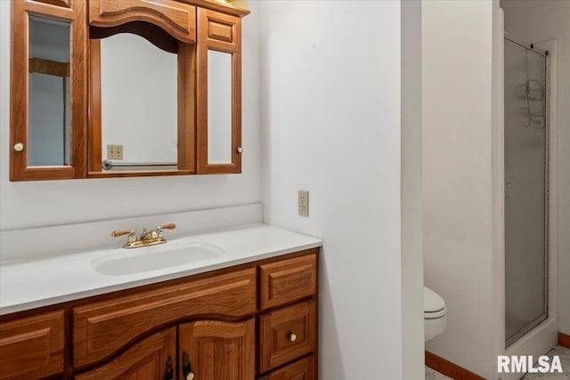 bathroom featuring vanity, toilet, and walk in shower