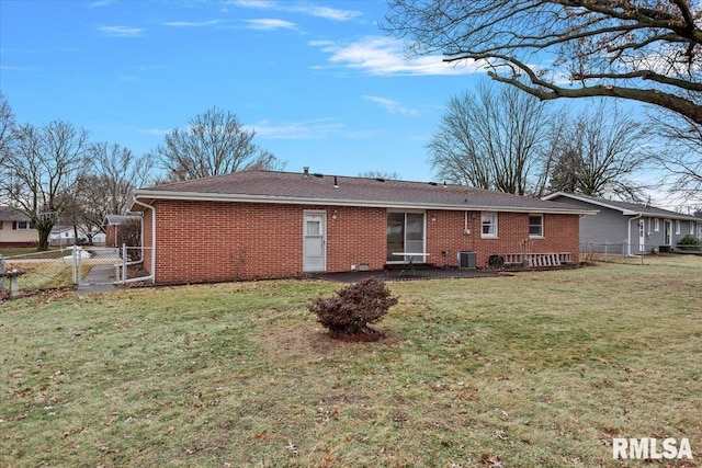 rear view of house featuring a lawn and central air condition unit