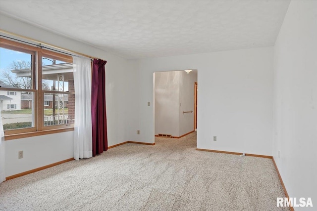 carpeted empty room featuring a textured ceiling