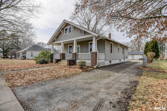 view of front facade featuring an outbuilding, a garage, and a porch