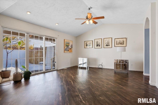 unfurnished room with lofted ceiling, dark wood-type flooring, and a wealth of natural light