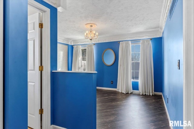 interior space featuring dark hardwood / wood-style flooring, a wealth of natural light, ornamental molding, and a textured ceiling