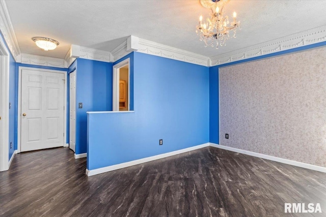 spare room with crown molding, dark wood-type flooring, a textured ceiling, and a chandelier