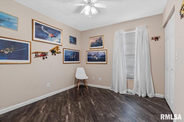 interior space featuring ceiling fan, dark hardwood / wood-style flooring, and a textured ceiling