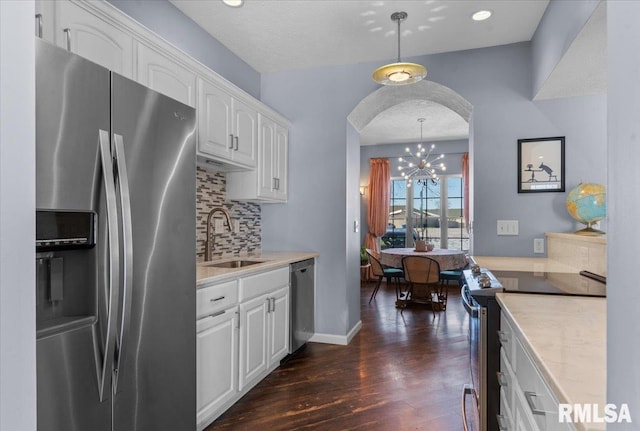 kitchen with stainless steel appliances, sink, pendant lighting, and white cabinets