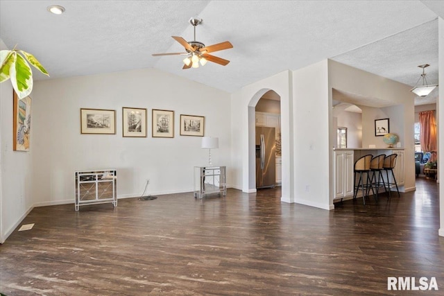 spare room featuring lofted ceiling, a textured ceiling, dark hardwood / wood-style floors, and ceiling fan