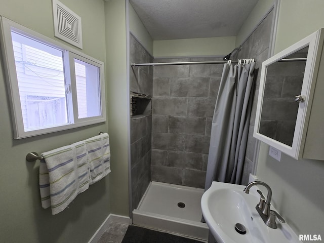 bathroom featuring sink, a textured ceiling, and a shower with shower curtain