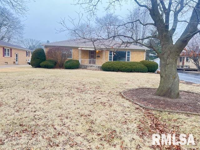 ranch-style house with a porch and a front yard