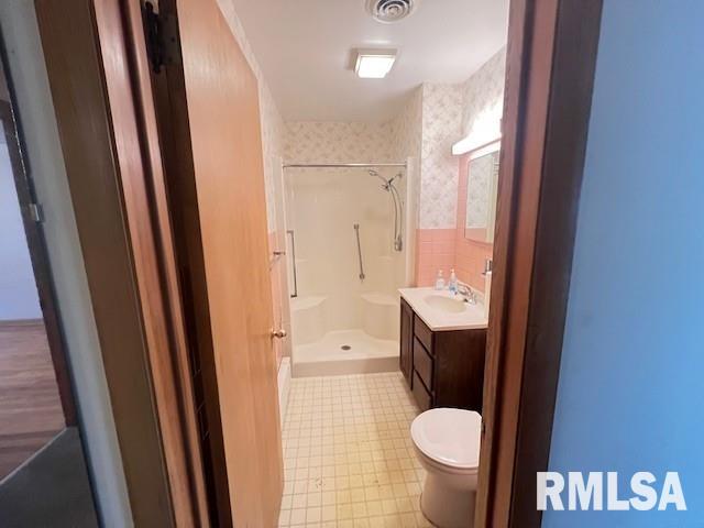 bathroom featuring walk in shower, vanity, and toilet