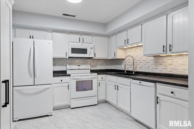 kitchen featuring sink, white cabinetry, a textured ceiling, white appliances, and decorative backsplash