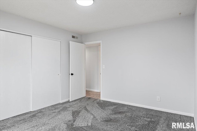 unfurnished bedroom with a closet, a textured ceiling, and carpet