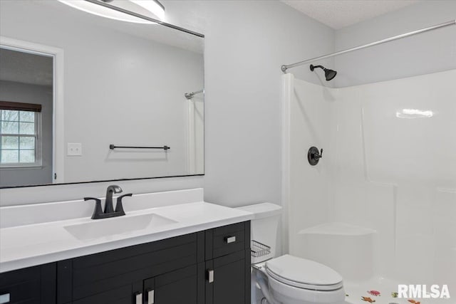 bathroom with vanity, a shower, a textured ceiling, and toilet