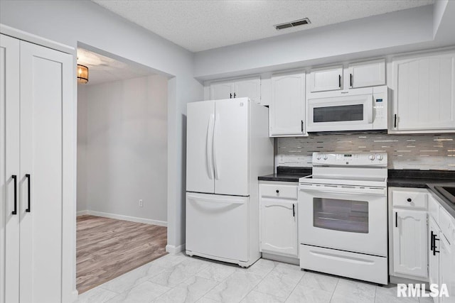 kitchen with white cabinetry, white appliances, decorative backsplash, and a textured ceiling