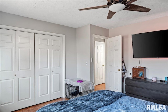 bedroom with hardwood / wood-style flooring, ceiling fan, a closet, and a textured ceiling