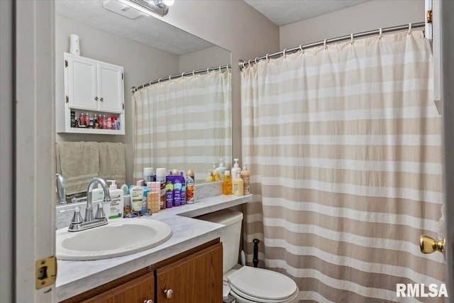 bathroom featuring vanity, toilet, and a textured ceiling