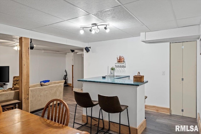 bar with hardwood / wood-style floors and a paneled ceiling