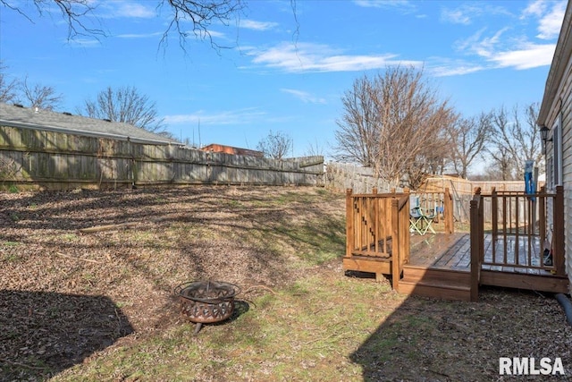 view of yard with a deck and a fire pit