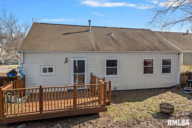 back of property featuring a fire pit and a deck