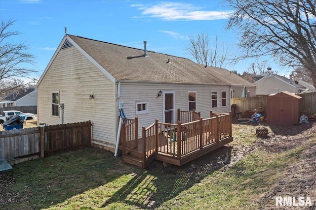 rear view of house featuring a wooden deck, a storage shed, and a yard