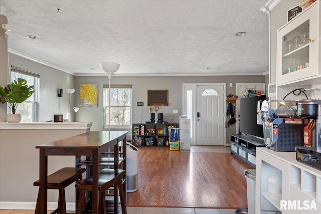 interior space with crown molding, hardwood / wood-style floors, and a textured ceiling