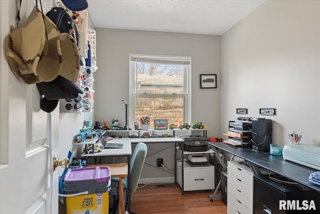 home office with dark hardwood / wood-style flooring and a textured ceiling