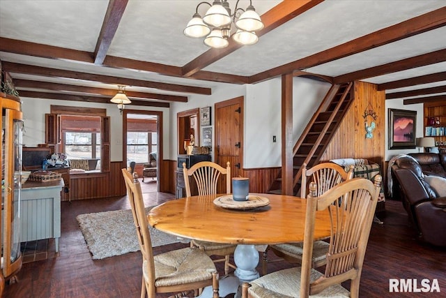 dining room with an inviting chandelier, dark hardwood / wood-style floors, wooden walls, and beam ceiling