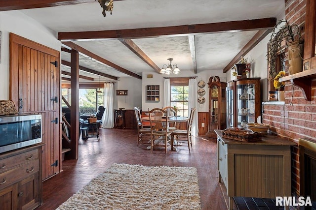 dining area with an inviting chandelier, dark hardwood / wood-style floors, and beam ceiling