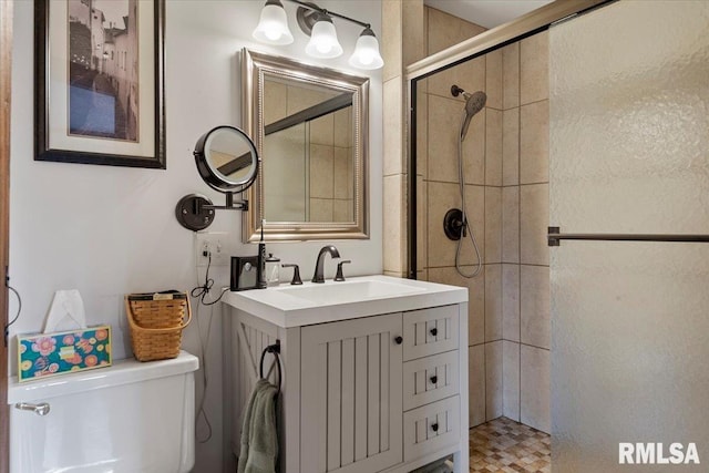 bathroom featuring vanity, an enclosed shower, and toilet