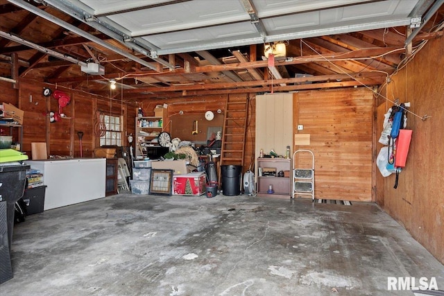 garage with a garage door opener and wooden walls