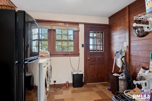 entrance foyer featuring washing machine and clothes dryer and wooden walls