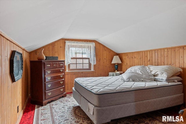 bedroom with wood-type flooring, wooden walls, and vaulted ceiling