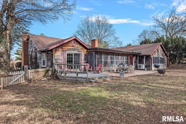 back of house featuring a yard, a sunroom, a patio, and a deck