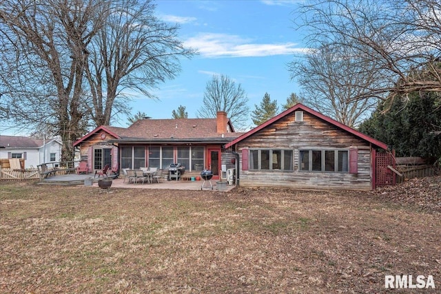 rear view of house with a patio, a sunroom, and a yard