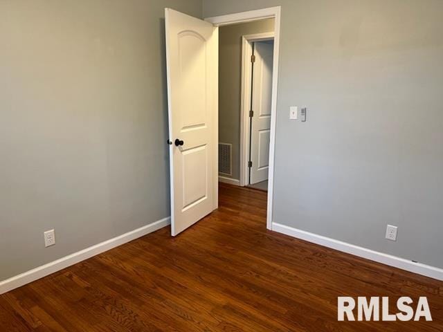 spare room with dark wood-type flooring