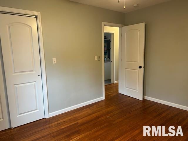 unfurnished bedroom with dark wood-type flooring