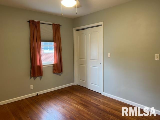 unfurnished bedroom featuring ceiling fan, dark hardwood / wood-style flooring, and a closet