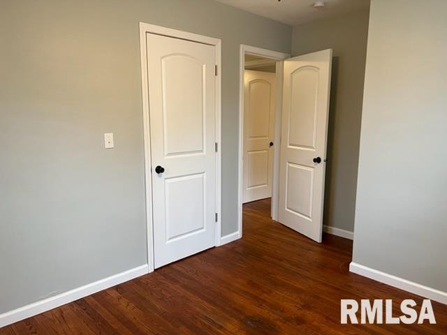 unfurnished bedroom with dark hardwood / wood-style flooring