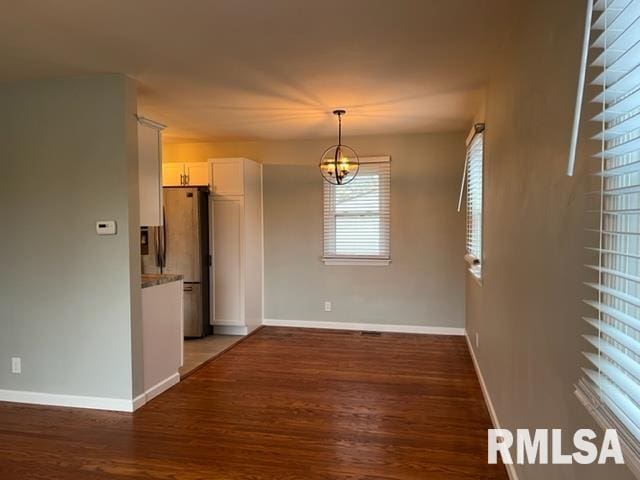 empty room featuring dark hardwood / wood-style floors and a chandelier