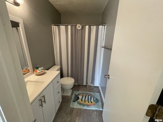 bathroom with hardwood / wood-style flooring, vanity, and toilet