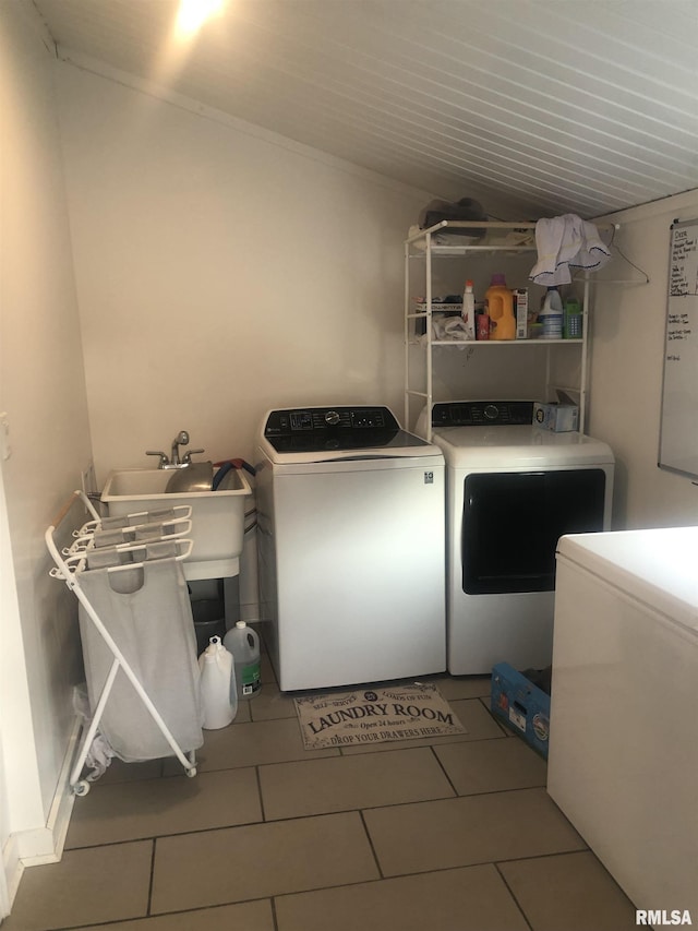 clothes washing area with tile patterned flooring, sink, and washing machine and clothes dryer